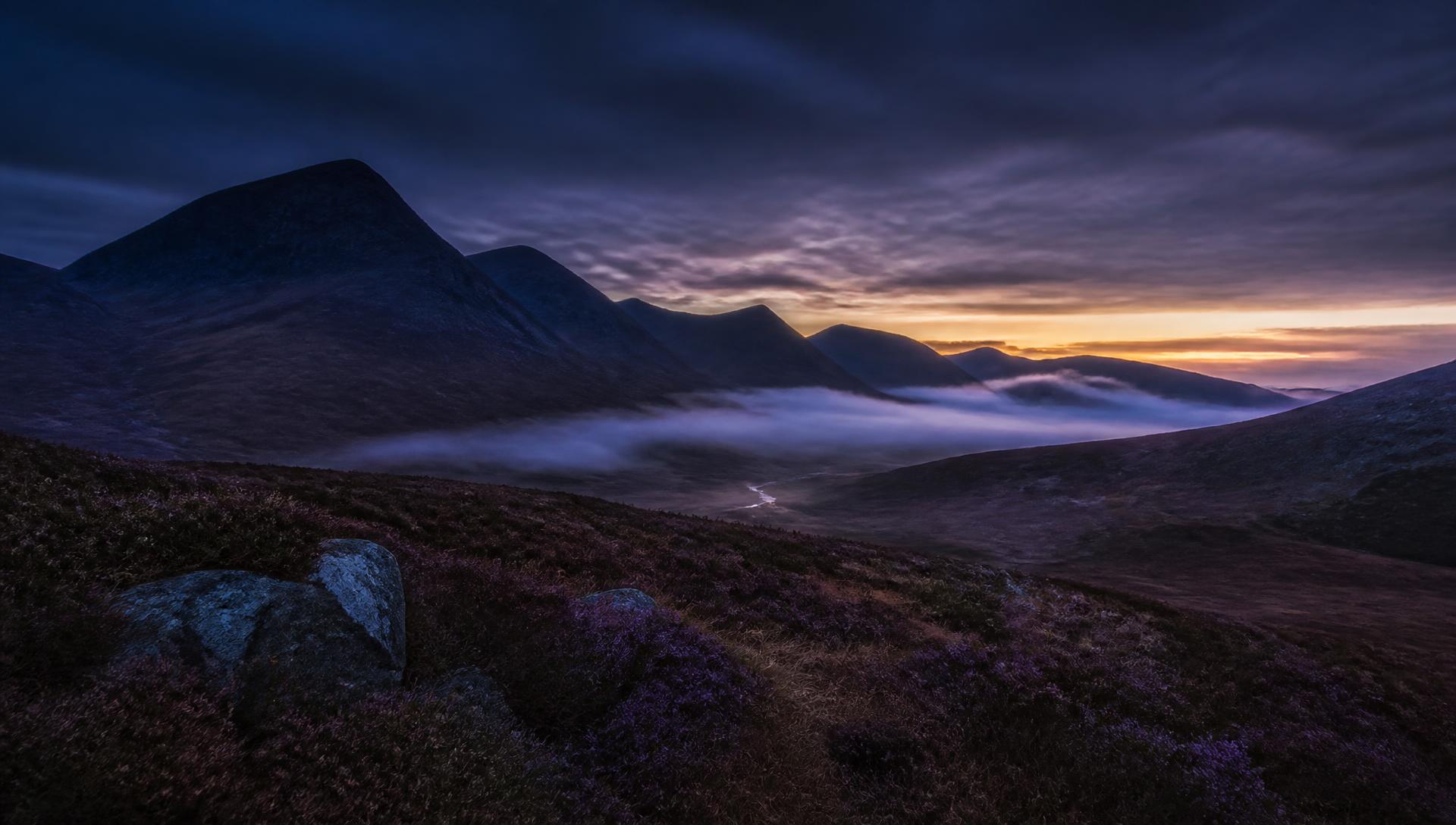 Scottish Highland landscape at dusk with mist lying in the glen